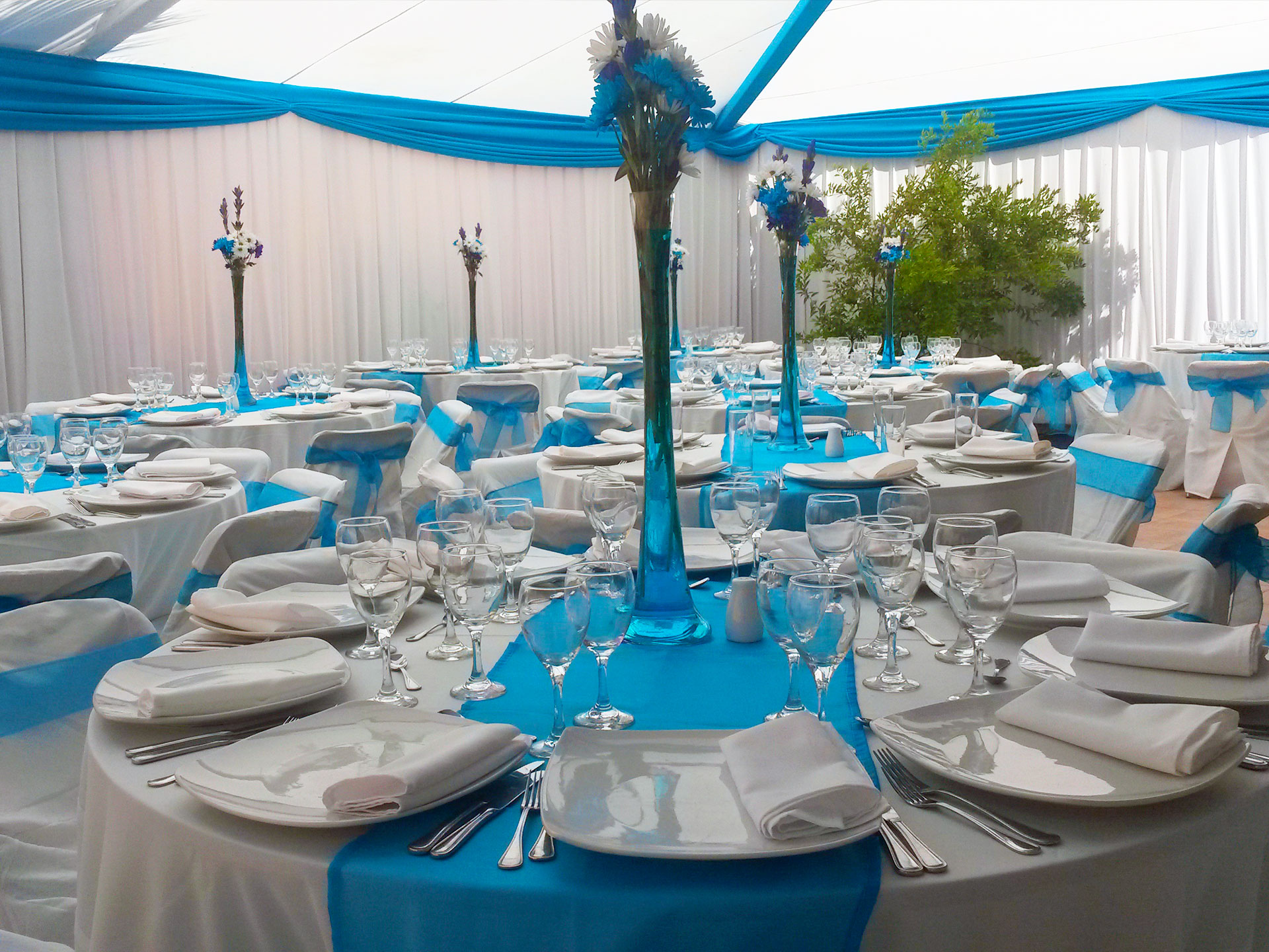 Montaje de evento BlueMoon con mesas blancas y decoración turquesa